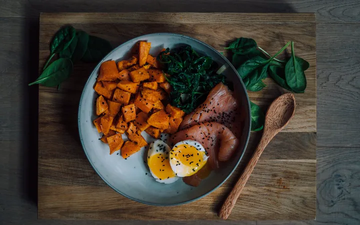 A bowl of salmon, roasted sweet potato, spinach and a soft-boiled egg