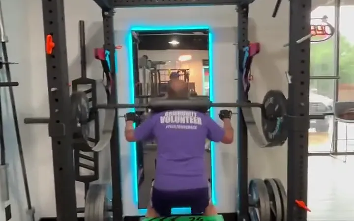 A client squatting in a power rack during a 1-on-1 session at The Gym TX